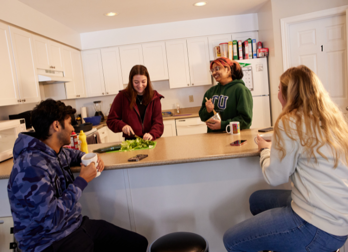 students in kitchen preparing a meal